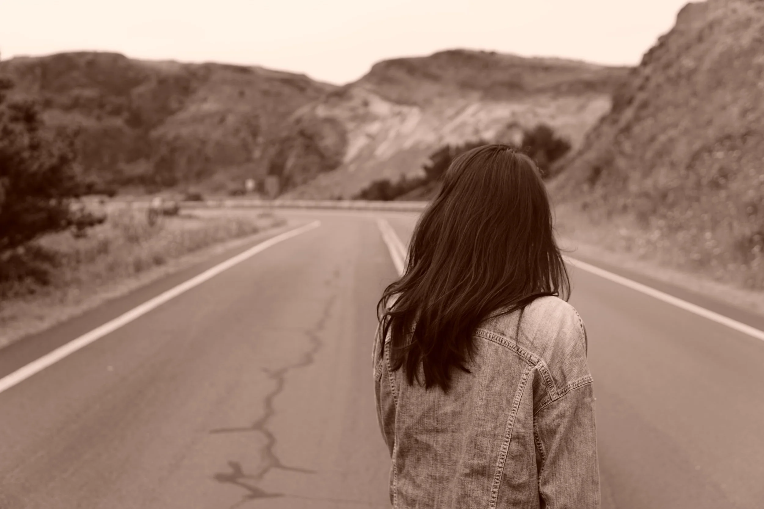woman walking on a open road I parent is grieving the loss of her pregnancy and infant loss and is going to online therapy in miami, florida at the heard counseling.