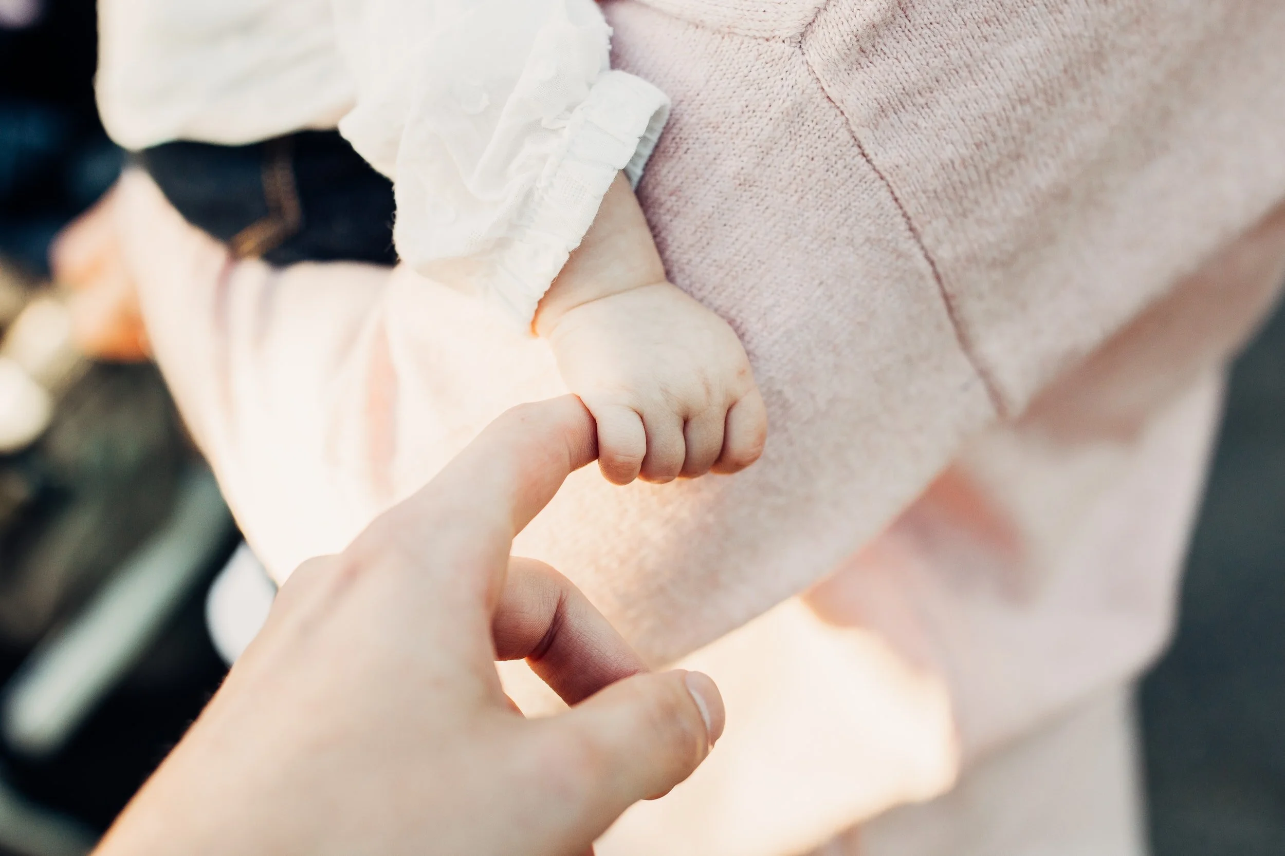A couple holds hands with their baby after a couples counseling in Miami for their birth trauma and ptsd from the birth of the baby, they are working with couples therapist in Miami , April Brown at the HEard Counseling.